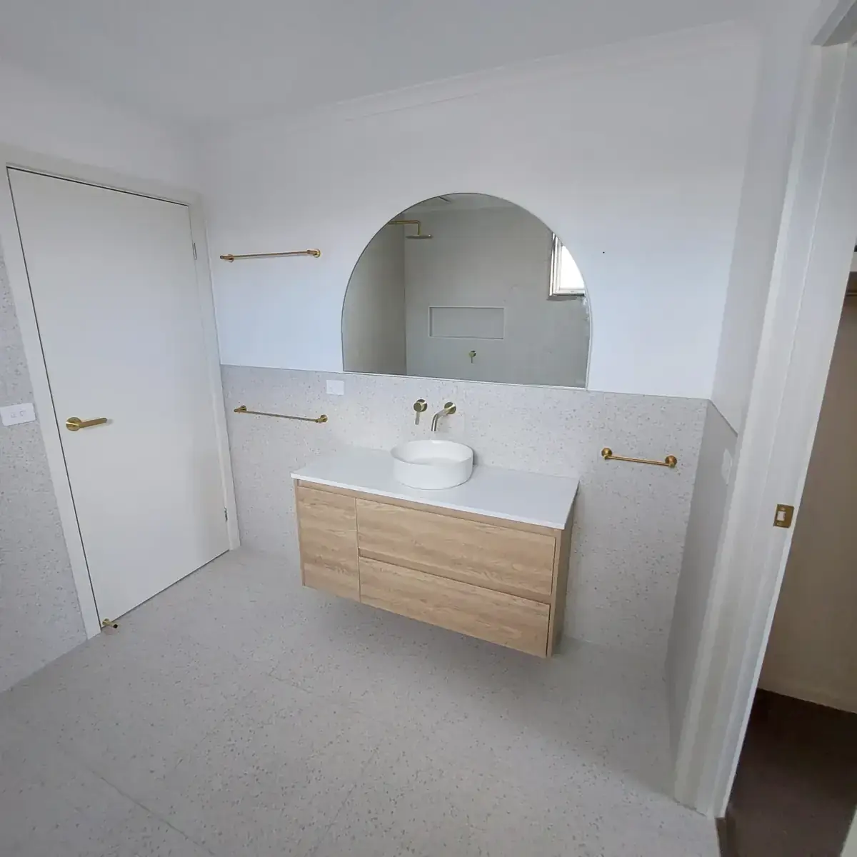 Yarraville ensuite with arch mirror and brass tapware
