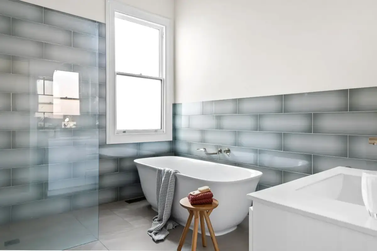 Premium RenoWorx bathroom renovation — freestanding tub with handcrafted blue subway tile